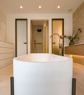 Bad von Haus U7a mit freistehender Wanne und warmen Naturmaterialien